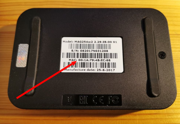 Parte trasera de un dispositivo MAG Box con etiqueta de modelo y número MAC, con una flecha roja señalando la información MAC.